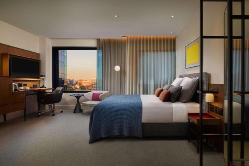 Next Hotel Melbourne, Curio Collection by Hilton tesisinde bir odada yatak veya yataklar